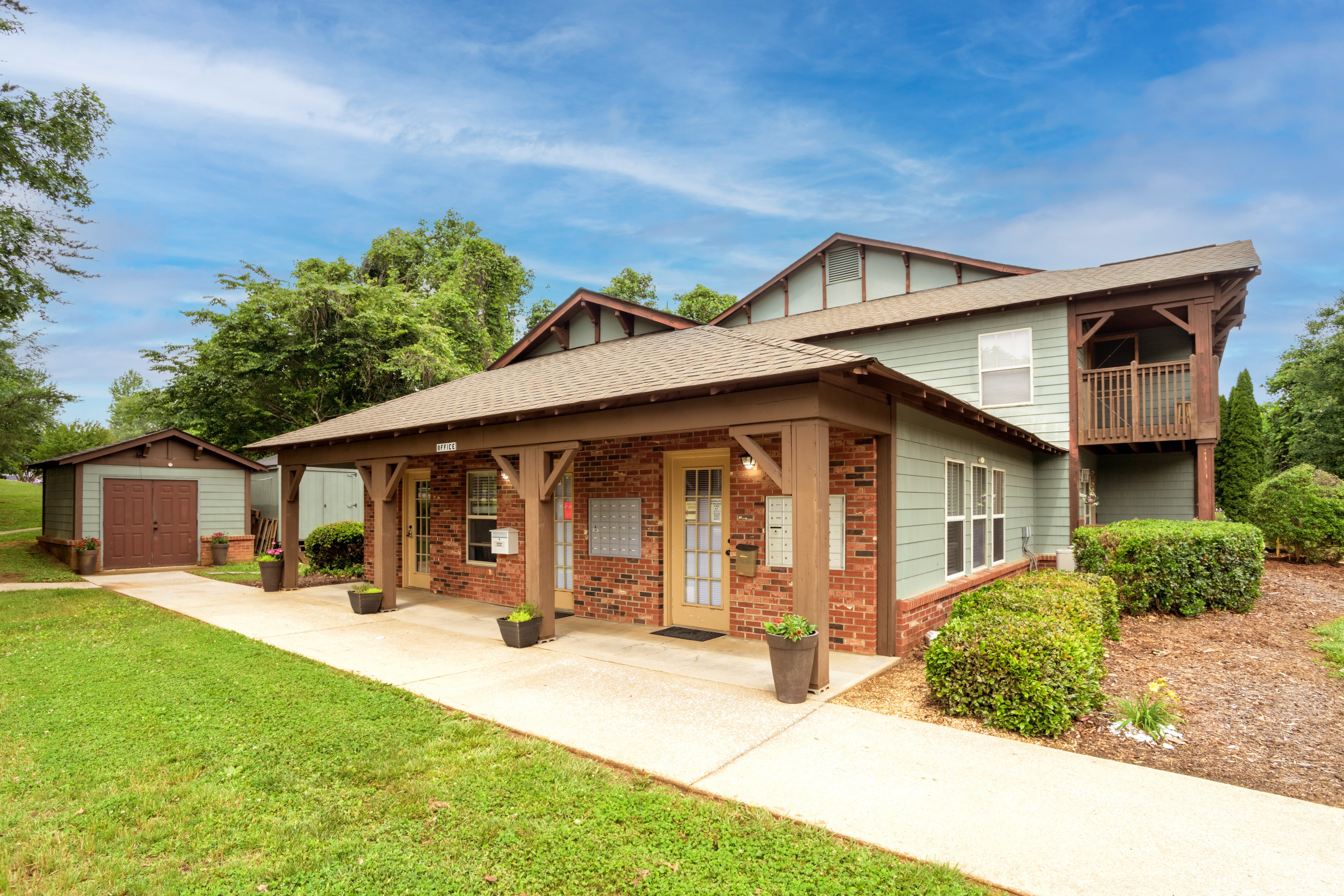 A house with a green lawn and a brown roof.,A house with a green lawn and a brown roof.